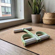 Kinava Green toning band with white-grey handle and footplate rails on the included workout mat