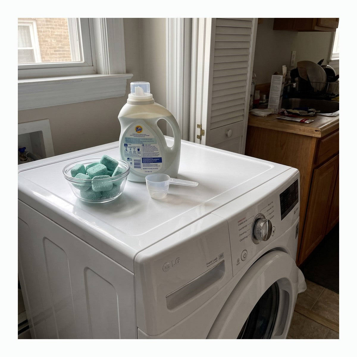 Mint washer cleaner tablets arranged beside a top-load washer