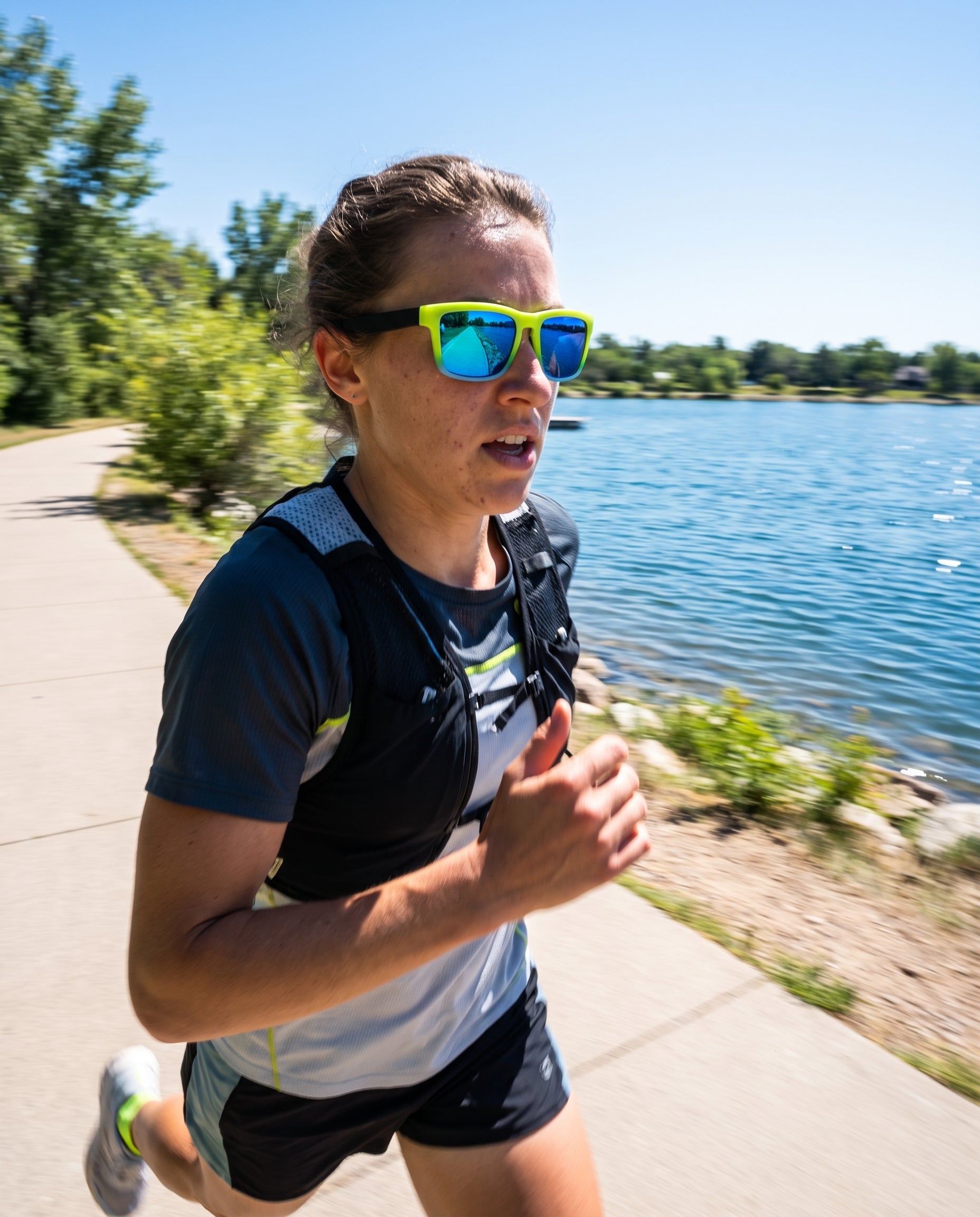 Runner wearing Kestryn polarized sunglasses on a sunlit waterside trail